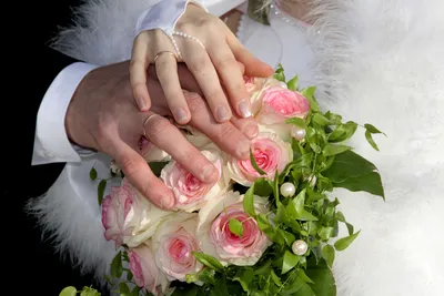 Цветочные композиции в объятиях рук с кольцом