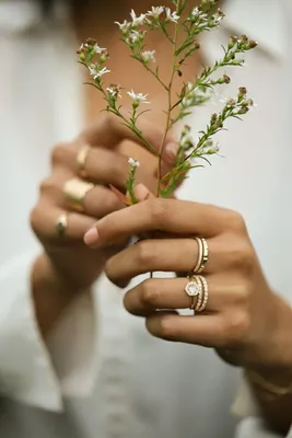 Игра красок и форм: руки, украшенные кольцом, с цветами